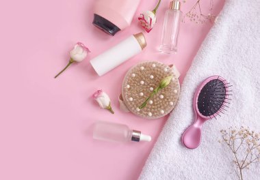 Şampuan, masaj fırçası, renkli bir arka planda tarak çiçeği.