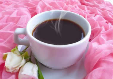 Bir fincan kahve çiçeği renkli bir arka planda güldü.