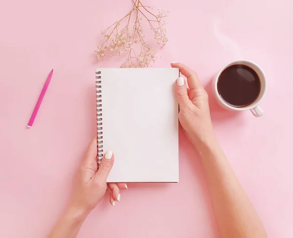 Weibliche Hände Mit Einer Tasse Kaffee Notizbuch Auf Farbigem Hintergrund — Stockfoto