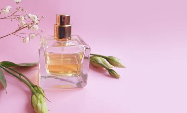 Renkli arka planda bir şişe parfümü çiçeği.