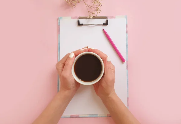 Weibliche Hände Mit Einer Tasse Kaffee Notizbuch Auf Farbigem Hintergrund — Stockfoto