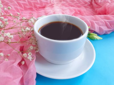 Bir fincan kahve çiçeği renkli bir arka planda güldü.