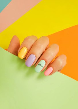 Kadın eli. Renkli arka planda güzel bir manikür.