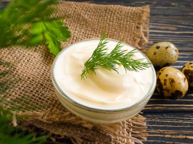 Ev yapımı mayonez, ahşap arka planda bıldırcın yumurtası.