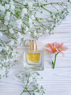 Ahşap bir arka planda şişe parfümü çiçeği.
