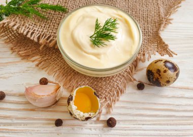 Ev yapımı mayonez, ahşap arka planda bıldırcın yumurtası.