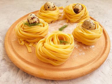 Çiğ makarna, arka planda bıldırcın yumurtası.