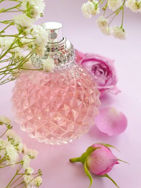 Renkli arka planda bir şişe parfümü çiçeği.