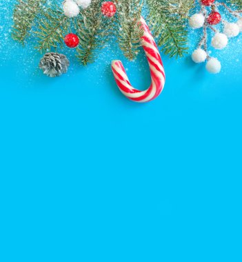 Noel ağacı dalı, renkli arkaplanda şekerler