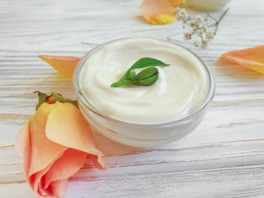 Ahşap arka plan nemlendiricisinde krem kozmetik çiçek