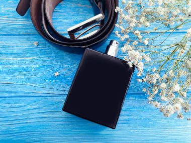 Parfüm şişesi, tahta arka planda kemer.