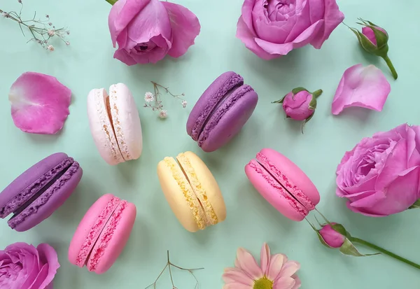 çok renkli badem kurabiyesi, renkli bir arka planda gül çiçeği.