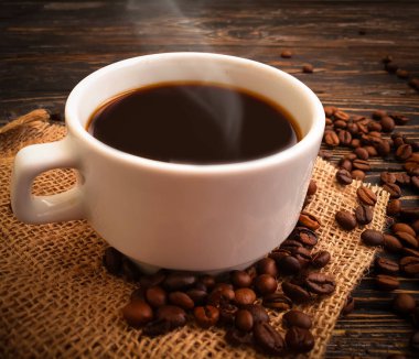 Ahşap arka planda kavrulmuş kahve çekirdekleri.