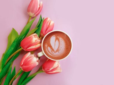  Bir fincan kahve. Renkli arkaplanda lale çiçeği