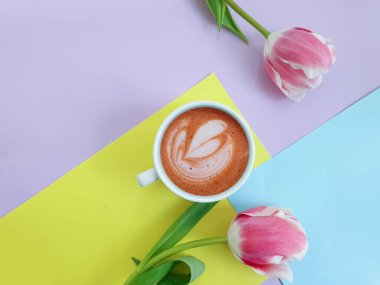 Bir fincan kahve. Renkli arkaplanda lale çiçeği