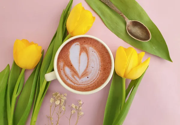 cup of coffee. tulip flower on colored background