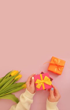 Kadın elleri hediye kutusunu tutar, lale çiçeği.