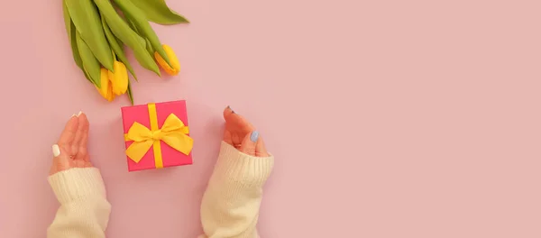 female hands hold a gift box, tulip flower