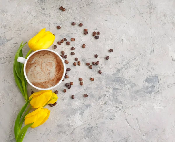 flower tulip, cup of coffee on concrete background