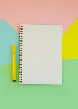 Renkli kağıdın arkaplanındaki keçeli kalem, defter