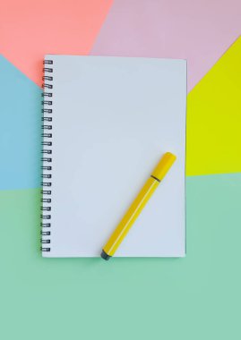 Renkli kağıdın arkaplanındaki keçeli kalem, defter