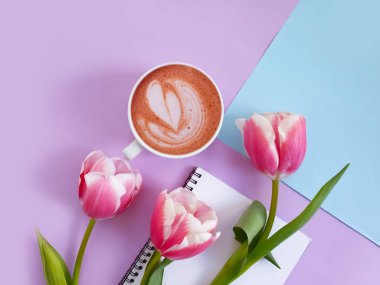 Bir fincan kahve. Renkli arkaplanda lale çiçeği