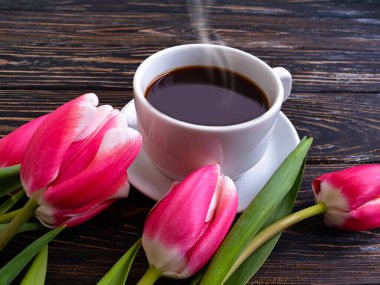 Bir fincan kahve çiçeği lalesi ahşap arka planda