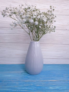 Tahta arkaplanda vazoda çikila çiçeği