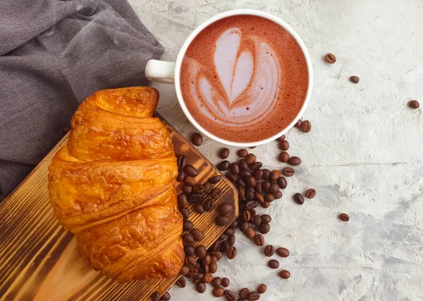 coffee cup, croissant on wooden background bakery