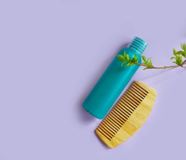 Şampuan, ahşap tarak, renkli bir arka plan.