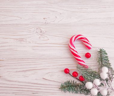 Noel ağacının dalı, ahşap arka planda şekerler.