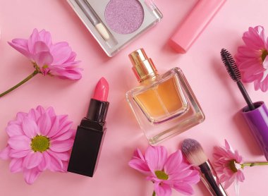 Şişe parfümü, dekoratif kozmetik, renkli bir arka planda çiçek.