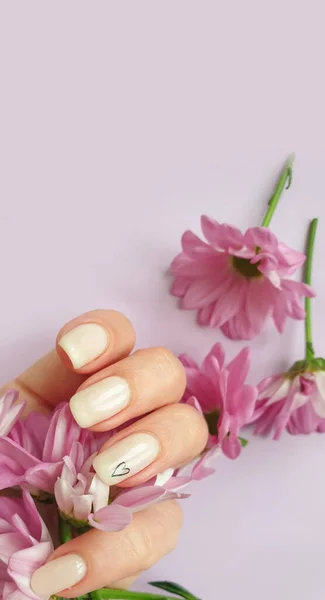 女性的手漂亮的指甲 花在彩色背景上 — 图库照片