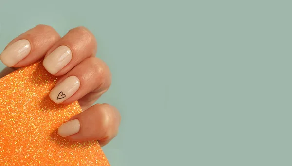 有色背景的漂亮的米色女性手指甲 — 图库照片