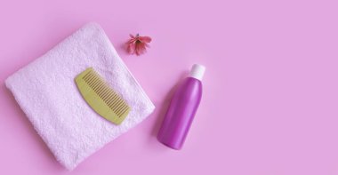 Tahta tarak, havluyla şampuan rengi arka planda.