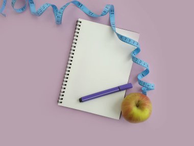 defter, mezura, renkli arkaplanda elma