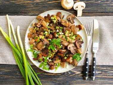 fried mushrooms in a plate on a wooden background