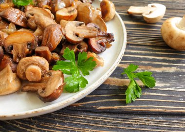 fried mushrooms in a plate on a wooden background