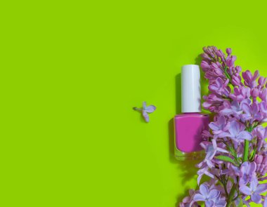 Renkli arkaplan çiçekli leylak renginde oje şişesi.
