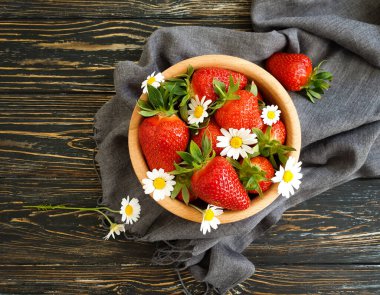 olgun çilek, ahşap arka planda papatya çiçeği