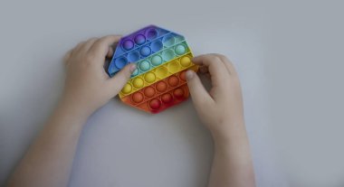 Çocuğun ellerinde stres önleyici bir oyuncak var.