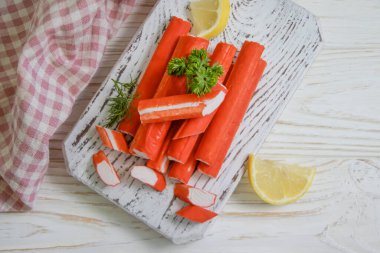 Yengeç sopaları, ahşap arka planda maydanoz.