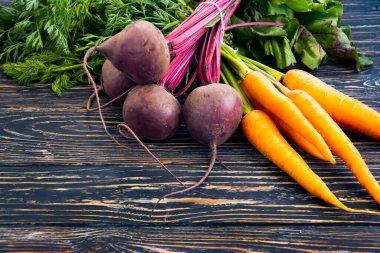 Tahta bir arka planda pancar ve havuç.