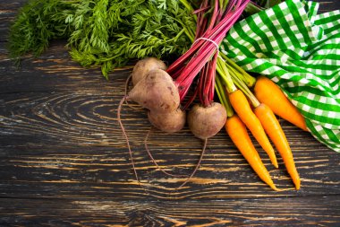 Tahta bir arka planda pancar ve havuç.