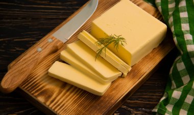 Tahta arka planda dilimlenmiş tereyağı