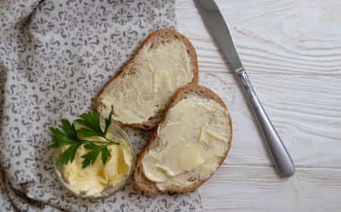 Tahta arka planda tereyağı, ekmek, maydanoz