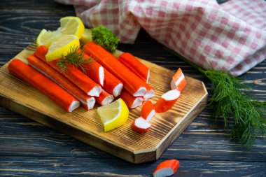 Yengeç sopaları, ahşap arka planda maydanoz.