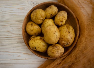 Ahşap arka planda çiğ patates 