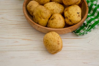 Ahşap arka planda çiğ patates 