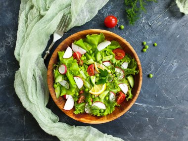 Beton arka planda bir tabakta salata